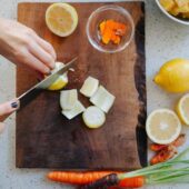 hands slicing lemons and turmeric