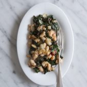 swiss chard and white beans on white plate with fork