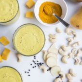 turmeric smoothies in glass with turmeric, mango, cashew