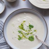 sunchoke soup in bowl with spoon and pesto
