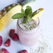 strawberry pineapple smoothie in glass with hemp seeds, mint, banana, pineapple