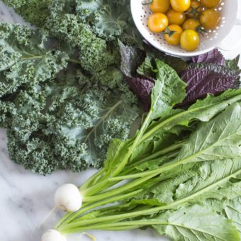 kale, shiso, turnips and tomatoes in a white bowl