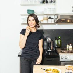 image of desiree nielsen RD in kitchen, eating an apple