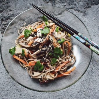 tofu vegetable stirfry on a glass plate with chopsticks