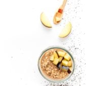 overnight oats in a glass jar with plums and a spoon