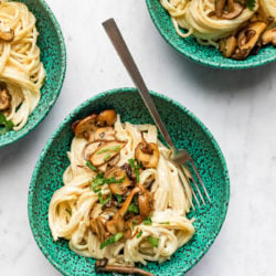 3 green bowls with vegan cashew alfredo pasta and mushrooms