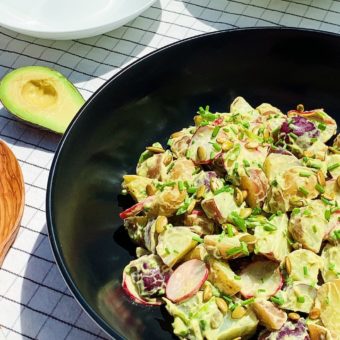 vegan potato salad with avocado ranch dressing in black bowl