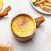 mug of apple cider with cinnamon sticks, ginger and lemon