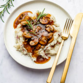 vegan mushroom gravy on potatoes with fork and knife