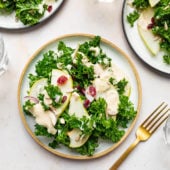 pear and kale salad with creamy tahini dressing on plates with a fork