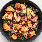 winter kale panzanella salad with squash and pomegranate in black bowl