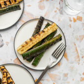 white plates with grilled zucchini and glasses of water
