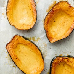 roasted acorn squash halves on baking sheet