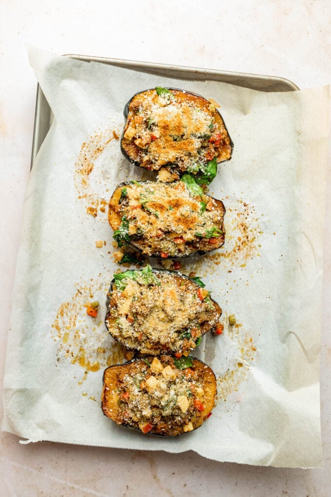 stuffed acorn squash on baking sheet