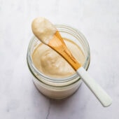 tahini dressing in jar with spoon on top