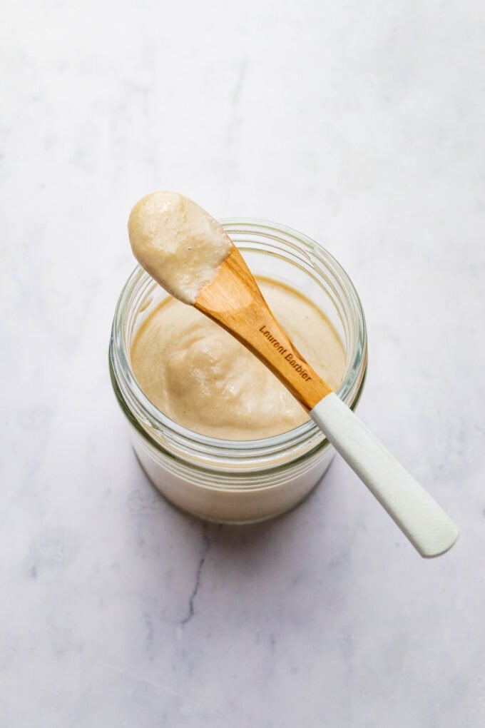 tahini dressing in jar with spoon on top