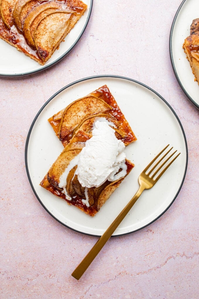 pear dessert tart with ice cream on a white plate with fork