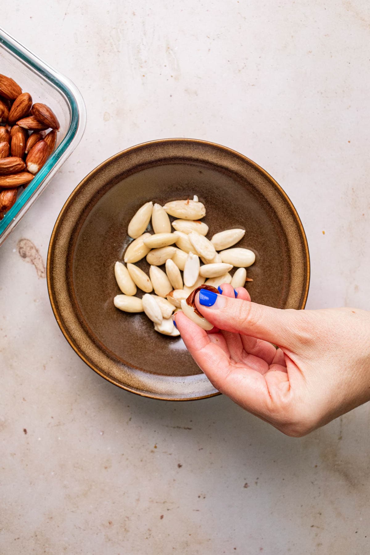 hand removing almond skins