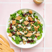 beet arugula salad in white bowl with dressing