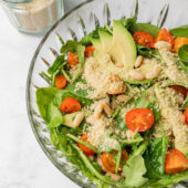 spinach arugula salad in glass bowl with dressing