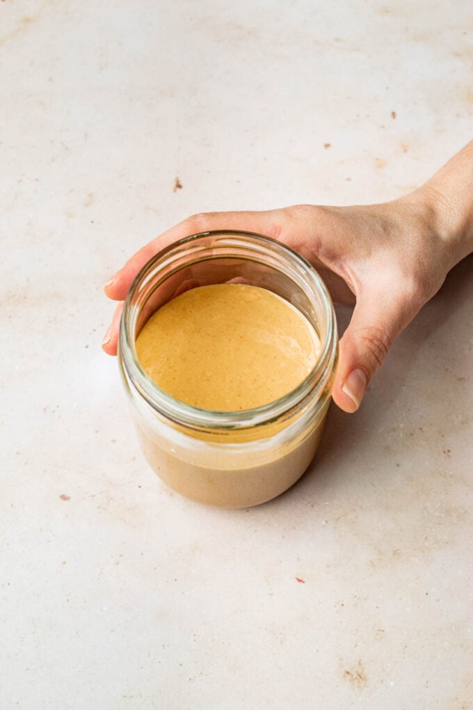 hand holding jar of homemade peanut butter