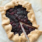 blackberry galette on parchment with a slice removed