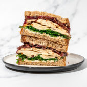 Shaved tofu and red onion sandwich on white and black plate