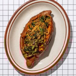 sweet potato stuffed with lentils and spinach on a brown edged oblong plate