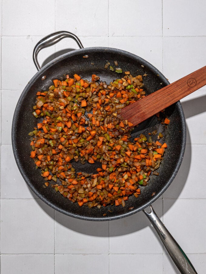 stirring cooked carrots, mushrooms and onions in skillet