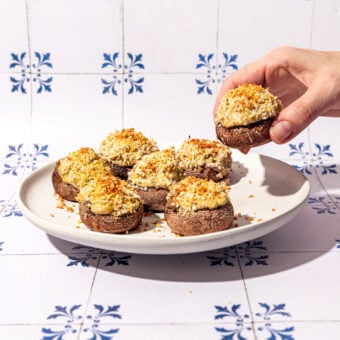 hand holding artichoke and tofu stuffed mushroom