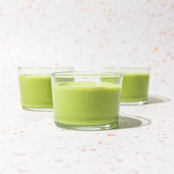 three glasses of green smoothie on terrazzo backdrop