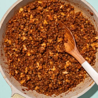 beige skillet with lentil walnut taco filling and wooden spoon