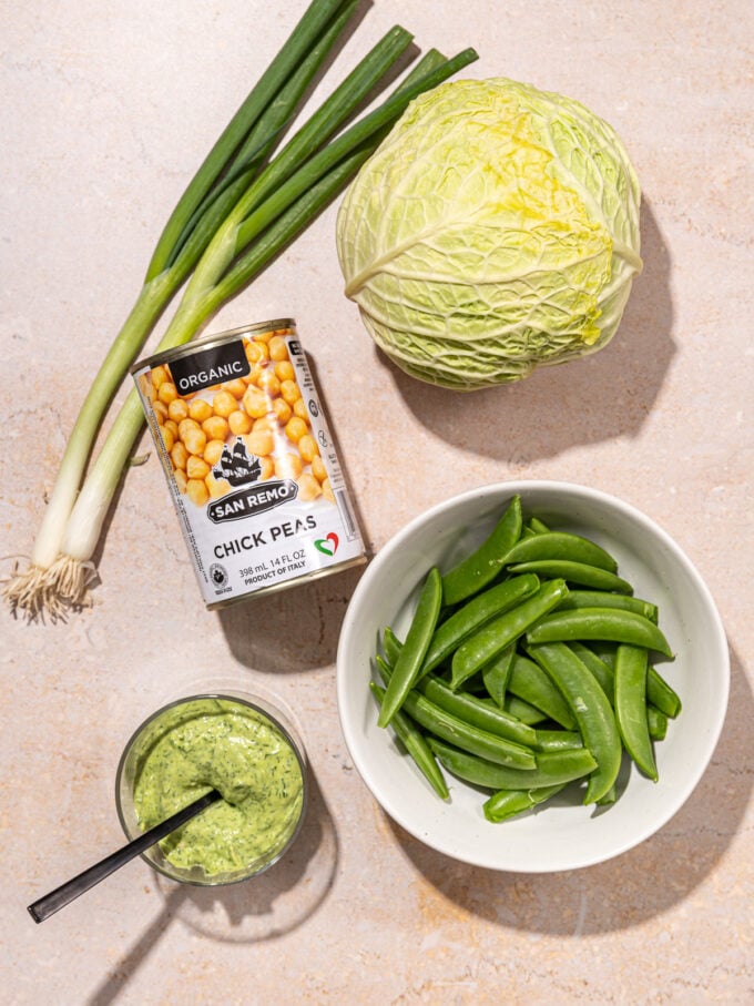 can of chickpeas, savoy cabbage, bowl of snap peas plus green goddess dressing
