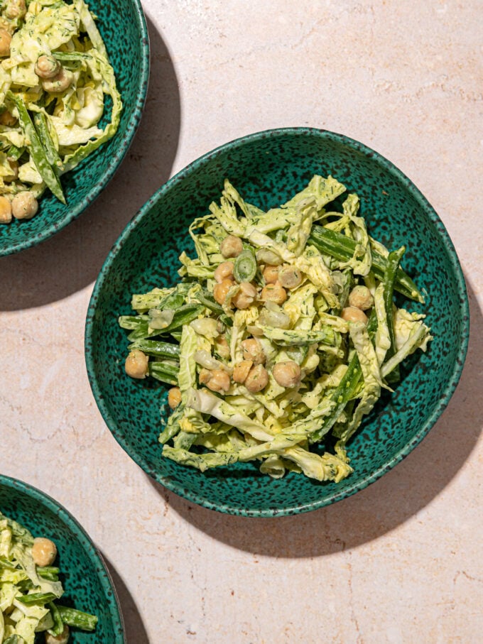 green goddess shredded cabbage and chickpea salad in 3 blue bowls