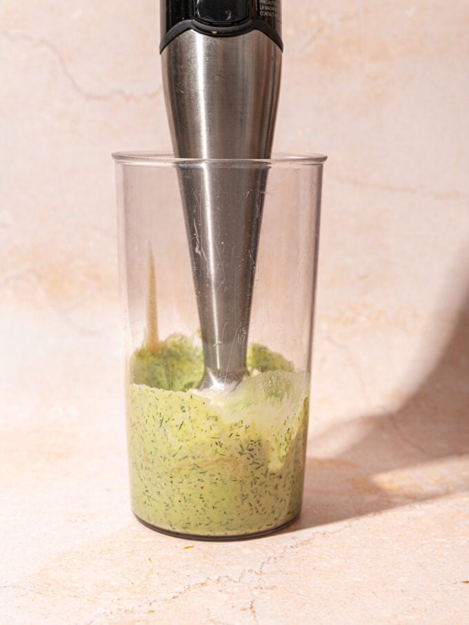 immersion blender with green goddess dressing in blender cup