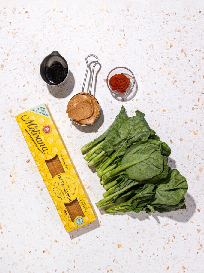 box of high protein pasta, choy sum, cups of peanut butter, soy sauce and red curry paste