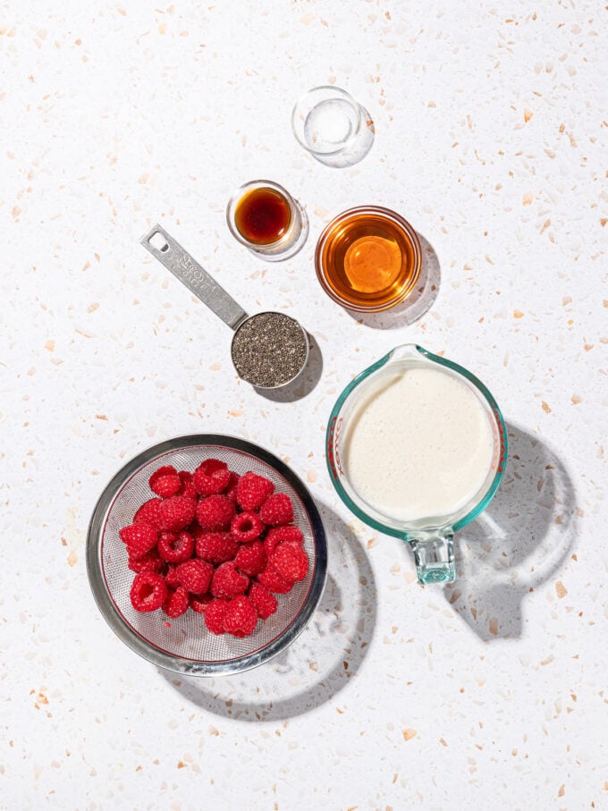 bowls of raspberries, milk, chia seeds, vanilla, maple syrup and salt