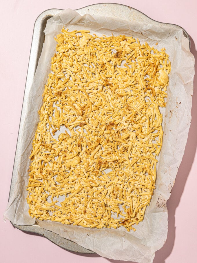 Une plaque à pâtisserie recouverte de papier sulfurisé et garnie de tofu cuit au four