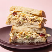 stacked halves of a tofu "chicken" salad sandwich on a purple plate