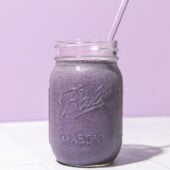 blueberry chickpea smoothie in mason jar with lavender coloured straw