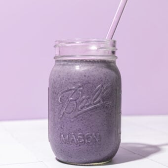 blueberry chickpea smoothie in mason jar with lavender coloured straw