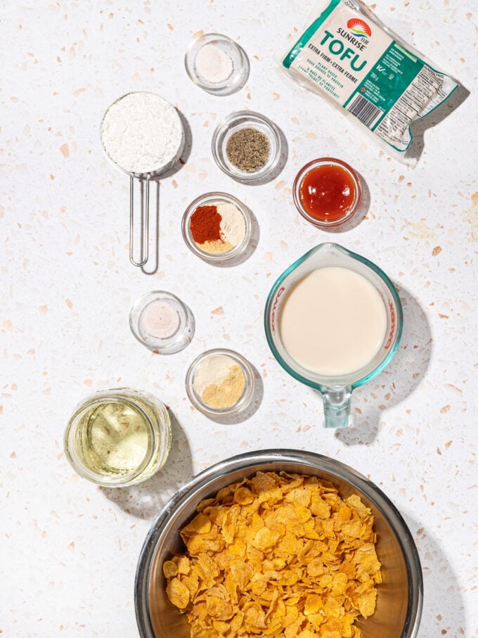 bowls of ingredients: cornflakes, milk, tofu, hot sauce, oil, spices, cornstarch