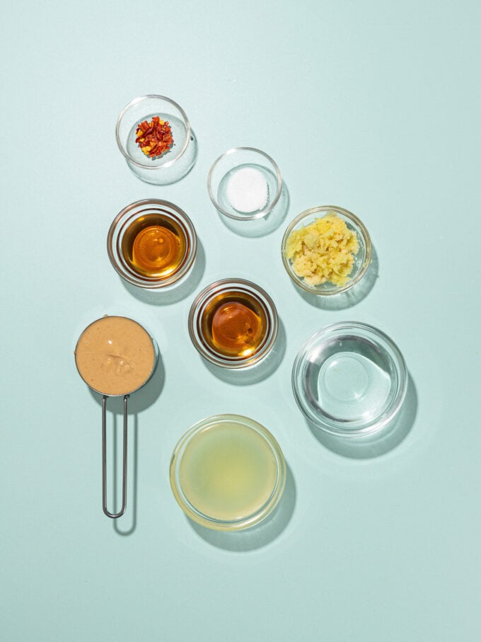 small bowls of ingredients: cashew butter, lime juice, sesame oil, maple syrup, fresh ginger and salt