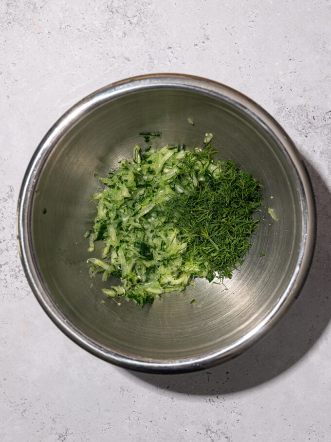 metal bowl with dill and grated cucumber